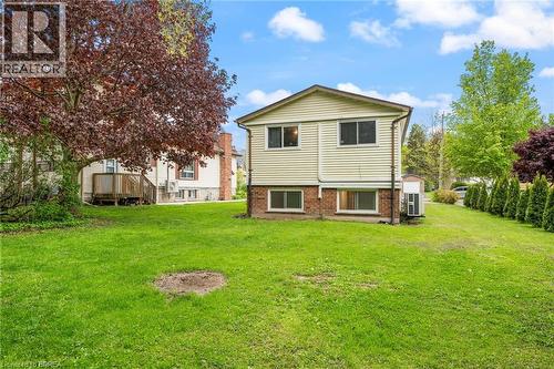 Expansive lawn area featuring a multi-story exterior with light-colored siding and a brick lower level - 9 Cherry Street, Simcoe, ON - Outdoor