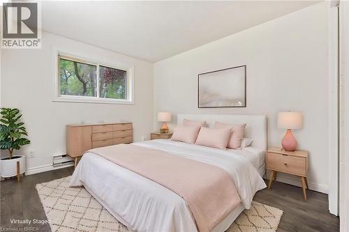 Bright room with a window providing natural light, white walls, and dark wood-finish flooring - 9 Cherry Street, Simcoe, ON - Indoor Photo Showing Bedroom