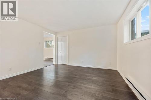Spacious interior room featuring wood-finish flooring, light-toned walls, and white trim - 9 Cherry Street, Simcoe, ON - Indoor Photo Showing Other Room