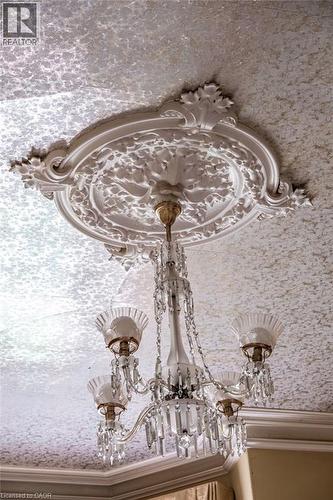 Ornate ceiling medallion with intricate detailing, featuring a multi-arm chandelier with glass shades and crystal accents - 370 Hess Street S, Hamilton, ON - 