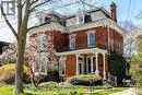 Brick exterior featuring an intricate white cornice, multiple dormer windows, a covered front porch with decorative columns, and an ornate second-story balcony - 370 Hess Street S, Hamilton, ON  - Outdoor 
