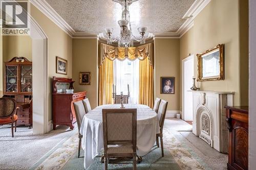 Formal dining room featuring an ornate ceiling, decorative crown molding, and an elegant chandelier - 370 Hess Street S, Hamilton, ON - Indoor Photo Showing Dining Room