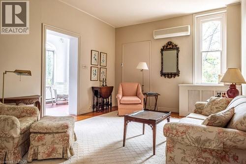 Living area featuring light beige walls, wood-finish flooring, and a large window with white trim - 370 Hess Street S, Hamilton, ON - Indoor Photo Showing Living Room