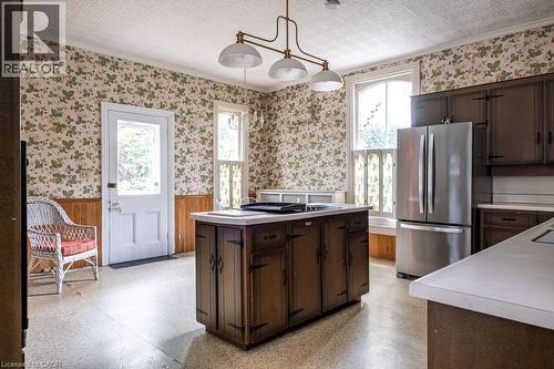 Kitchen featuring a central island with integrated storage, dark wood cabinetry, and a white countertop - 370 Hess Street S, Hamilton, ON - Indoor Photo Showing Kitchen