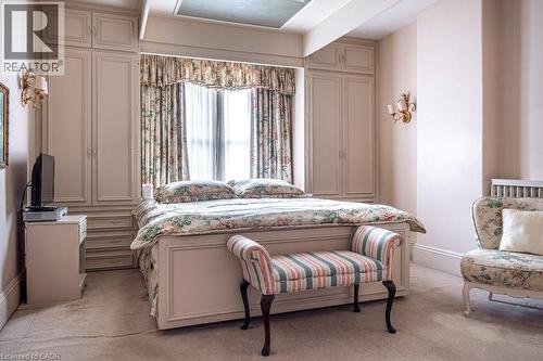 Recessed window with decorative drapes, flanked by built-in cabinetry featuring paneled doors and drawer storage - 370 Hess Street S, Hamilton, ON - Indoor Photo Showing Bedroom