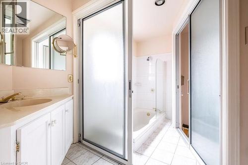 Bathroom featuring a white vanity with integrated sink, brass-finish faucet, and a large wall mirror - 370 Hess Street S, Hamilton, ON - Indoor Photo Showing Bathroom