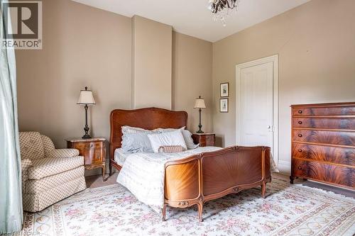Spacious room featuring neutral painted walls, light wood-finish flooring, a decorative area rug, and a ceiling-mounted light fixture - 370 Hess Street S, Hamilton, ON - Indoor Photo Showing Bedroom