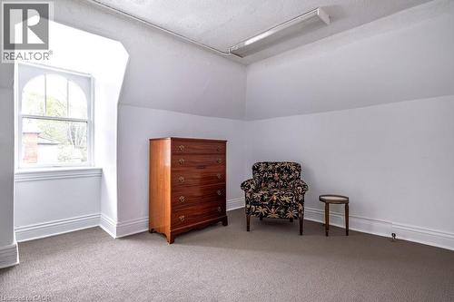 Room featuring an arched window, sloped ceiling, light gray carpeting, crisp white walls, and a fluorescent overhead light fixture - 370 Hess Street S, Hamilton, ON - Indoor