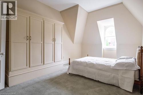 Attic room featuring a built-in wardrobe with panel doors and brass hardware - 370 Hess Street S, Hamilton, ON - Indoor Photo Showing Bedroom