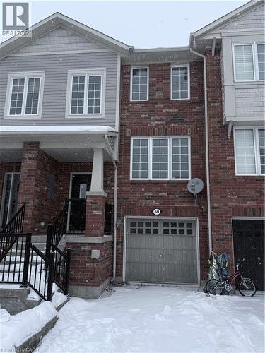 Brick facade townhome featuring a single-car garage with a paneled door - 50 Emick Drive, Ancaster, ON - Outdoor