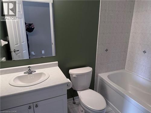 Bathroom featuring a white vanity with an integrated sink, chrome faucet, wall-mounted mirror, and a white toilet - 50 Emick Drive, Ancaster, ON - Indoor Photo Showing Bathroom
