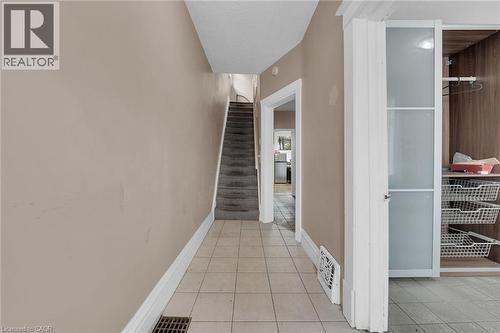 Foyer featuring neutral wall tones, white baseboards, and square tile flooring - 738 King Street W, Hamilton, ON - Indoor Photo Showing Other Room