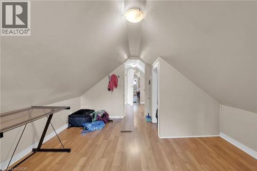 Attic space featuring sloped ceilings, wood-finish flooring, and light neutral wall tones - 738 King Street W, Hamilton, ON - Indoor Photo Showing Other Room