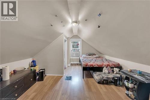 Attic room featuring sloped ceilings, wood-finish flooring, and a single window - 738 King Street W, Hamilton, ON - Indoor