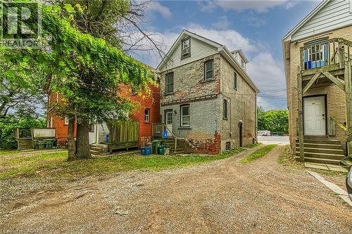 Three-story structure featuring a combination of brick and siding, a dormer window, and a gravel drive - 738 King Street W, Hamilton, ON - Outdoor