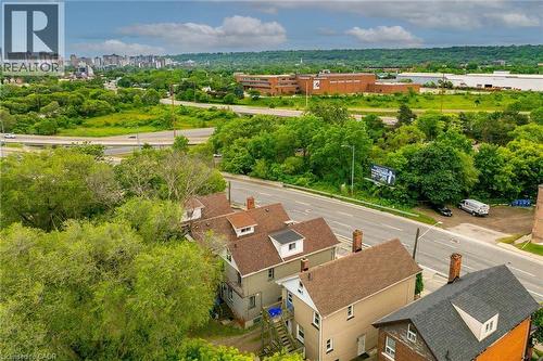Residential streetscape featuring multiple properties with dormer windows and shingle roofs - 738 King Street W, Hamilton, ON - Outdoor With View