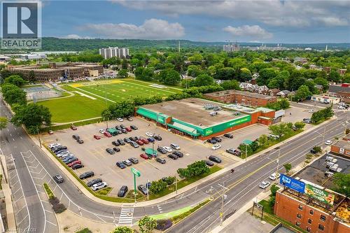 Retail building featuring a prominent corner location, expansive parking lot, and direct street access - 738 King Street W, Hamilton, ON - Outdoor With View