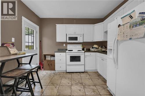 Kitchen featuring white cabinetry, dark countertops, and tile flooring - 738 King Street W, Hamilton, ON - Indoor Photo Showing Kitchen