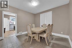 Dining area featuring neutral wall paint, tiled flooring, a window with horizontal blinds, and a ceiling-mounted light fixture - 