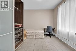 Neutral tone wall paint, tile flooring, and a large window with blinds - 