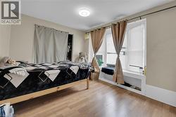 Room featuring wood-finish flooring, a contemporary flush-mount ceiling light, and neutral wall tones - 