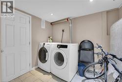 Dedicated laundry area featuring a white front-load washer and dryer, recessed lighting, and light-toned wall paint - 