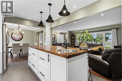 Kitchen island featuring a wood-finish countertop, undermount sink, and pendant lighting - 2116 Binbrook Road E, Hamilton, ON - Indoor Photo Showing Other Room