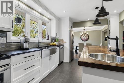Modern kitchen featuring white cabinetry, black countertops, and a subway tile backsplash - 2116 Binbrook Road E, Hamilton, ON - Indoor Photo Showing Kitchen With Double Sink