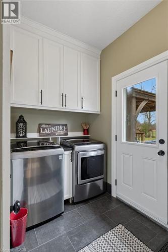 Dedicated laundry area featuring dark tile flooring and white cabinetry - 2116 Binbrook Road E, Hamilton, ON - Indoor Photo Showing Kitchen