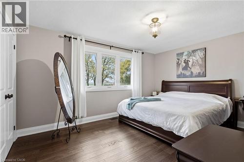 Bedroom featuring wood-finish flooring, a multi-pane window with white trim, and a ceiling-mounted light fixture - 2116 Binbrook Road E, Hamilton, ON - Indoor Photo Showing Bedroom