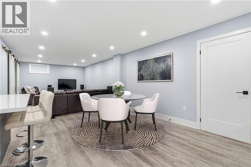 Spacious room featuring wood-finish flooring, recessed lighting, a built-in breakfast bar with a white countertop, and a modern interior door with black hardware - 2116 Binbrook Road E, Hamilton, ON - Indoor Photo Showing Dining Room