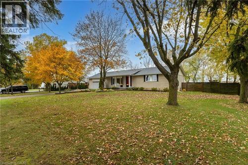 Expansive front lawn with mature trees and a paved driveway leading to a single-car garage - 2116 Binbrook Road E, Hamilton, ON - Outdoor