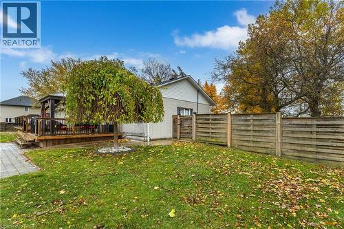 Expansive backyard featuring a wood deck with a built-in gazebo, a mature deciduous tree, a paved stone walkway, and a privacy fence - 2116 Binbrook Road E, Hamilton, ON - Outdoor