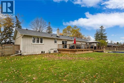 Expansive backyard featuring a large wood-finish deck with railing, a built-in gazebo, a light-colored brick exterior, and a privacy fence - 2116 Binbrook Road E, Hamilton, ON - Outdoor With Deck Patio Veranda