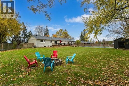 Expansive lawn with a built-in fire pit, privacy fencing, and mature trees - 2116 Binbrook Road E, Hamilton, ON - Outdoor With Backyard