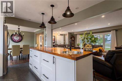 Kitchen island with a rich wood-finish countertop and integrated stainless steel sink - 2116 Binbrook Road E, Hamilton, ON - Indoor Photo Showing Kitchen With Double Sink