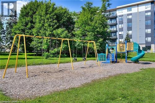 Outdoor play area featuring a swing set and a multi-level play structure with a slide - 247 Northfield Drive E Unit# 207, Waterloo, ON - Outdoor