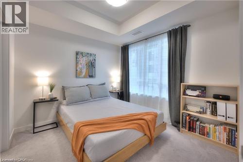 Neutral-toned bedroom featuring a prominent window, recessed ceiling, and light-colored carpeting - 247 Northfield Drive E Unit# 207, Waterloo, ON - Indoor Photo Showing Bedroom