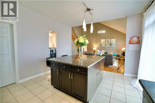 Kitchen island with a granite-style countertop and dark wood-finish cabinetry - 704 Zurich Drive, Waterloo, ON - Indoor