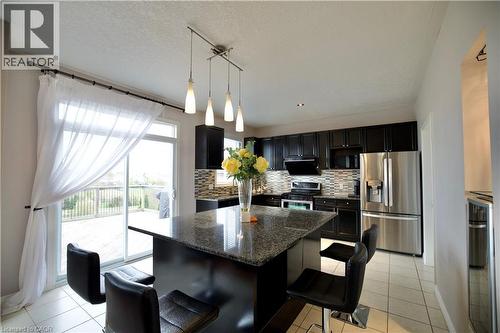 Kitchen featuring a dark granite island with pendant lighting, black cabinetry, and stainless steel appliances - 704 Zurich Drive, Waterloo, ON - Indoor Photo Showing Kitchen With Stainless Steel Kitchen With Upgraded Kitchen