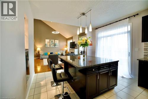 Kitchen island with a granite countertop and dark wood cabinetry - 704 Zurich Drive, Waterloo, ON - Indoor