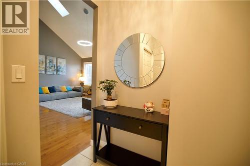 Entryway featuring tile flooring, a decorative round mirror, and a console table - 704 Zurich Drive, Waterloo, ON - Indoor