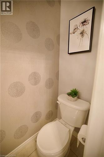 Powder room featuring contemporary patterned wallpaper and a white toilet - 704 Zurich Drive, Waterloo, ON - Indoor Photo Showing Bathroom