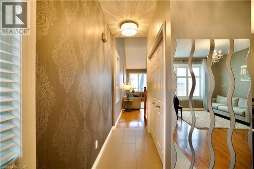 Hallway featuring patterned accent wall, tile flooring, and flush mount ceiling light - 704 Zurich Drive, Waterloo, ON - Indoor Photo Showing Other Room