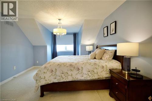 Attic room featuring sloped ceilings, a window with dark curtains, and light blue walls - 704 Zurich Drive, Waterloo, ON - Indoor Photo Showing Bedroom