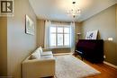 Room featuring wood-finish flooring, a prominent window with white blinds, and a decorative chandelier - 704 Zurich Drive, Waterloo, ON  - Indoor 