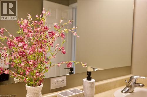 Bathroom vanity featuring a polished chrome faucet, white ceramic sink, and a large wall-mounted mirror - 704 Zurich Drive, Waterloo, ON - Indoor Photo Showing Bathroom