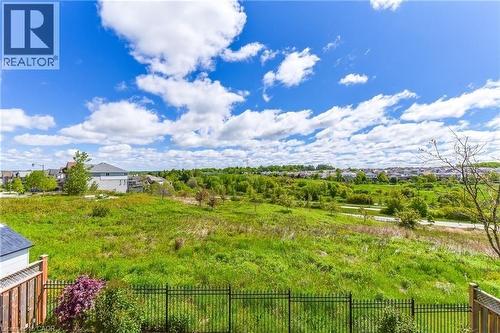 Expansive green space featuring a black metal fence, partial wood fence, and a small outbuilding - 704 Zurich Drive, Waterloo, ON - Outdoor With View
