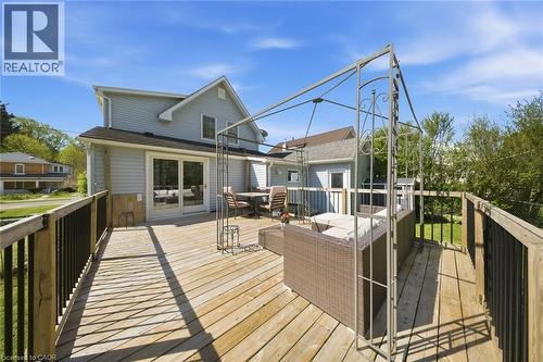 Expansive wooden deck featuring black railings and a metal pergola frame - 401 West Street, Simcoe, ON - Outdoor With Deck Patio Veranda With Exterior