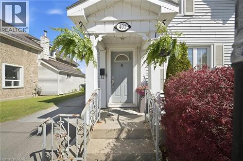 Front entrance featuring a light gray door with an arched window insert, flanked by white decorative columns - 401 West Street, Simcoe, ON - Outdoor